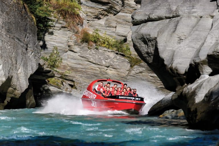 jet-boating-queenstown-shotover-jet-feature-1 | Must Do New Zealand Shot over jet speeding in the shot over river canyon