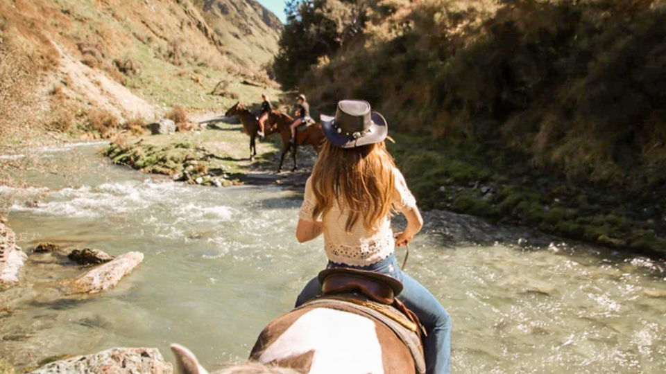 Female rider horse trek'n towards Moke Lake, Queenstown