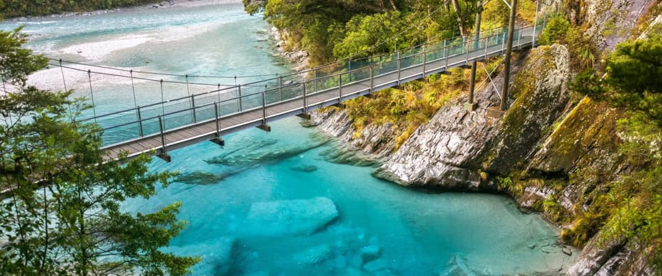 Swing bridge over the crystal-clear Blue Pools near Makarora