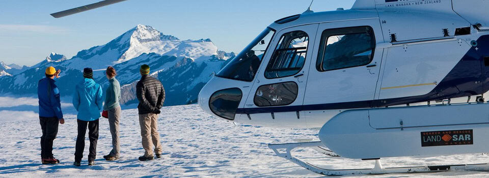 aspiring Helicopters with tourists experiencing a snow landing lake wanaka