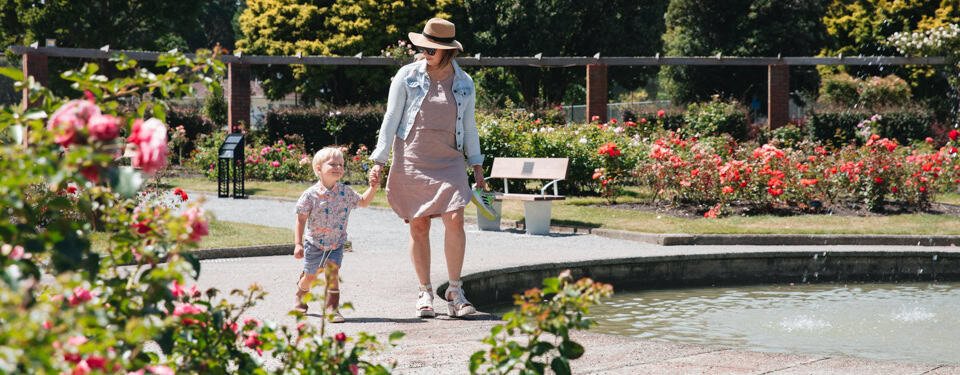 Young woman wit chils walking through Wellington's botanical gardens