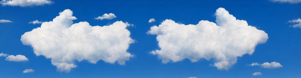 Bright blue sky with two large fluffy white cumulus clouds.